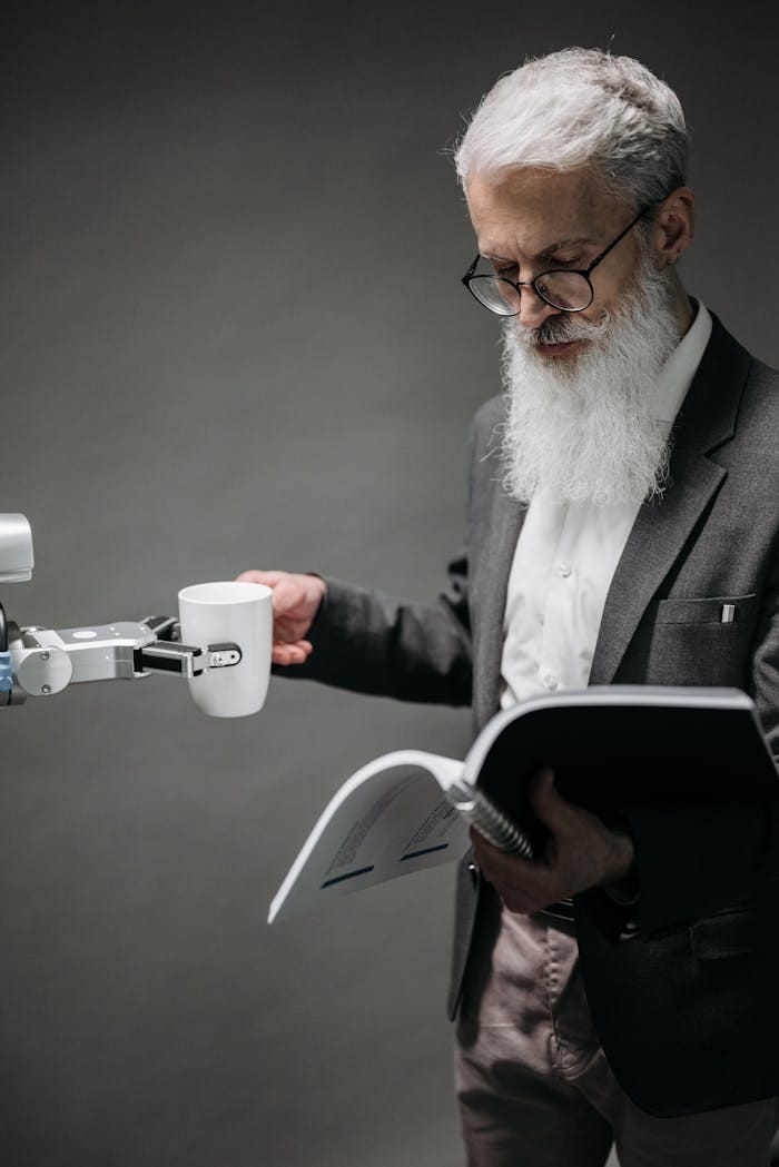 who-we-are-img An elderly scientist reads while a robot serves coffee, representing technology's role.